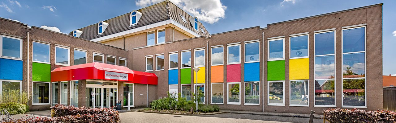 Entree van Medisch Centrum Dorp in Houten, met rode luifel en gekleurde gevelpanelen